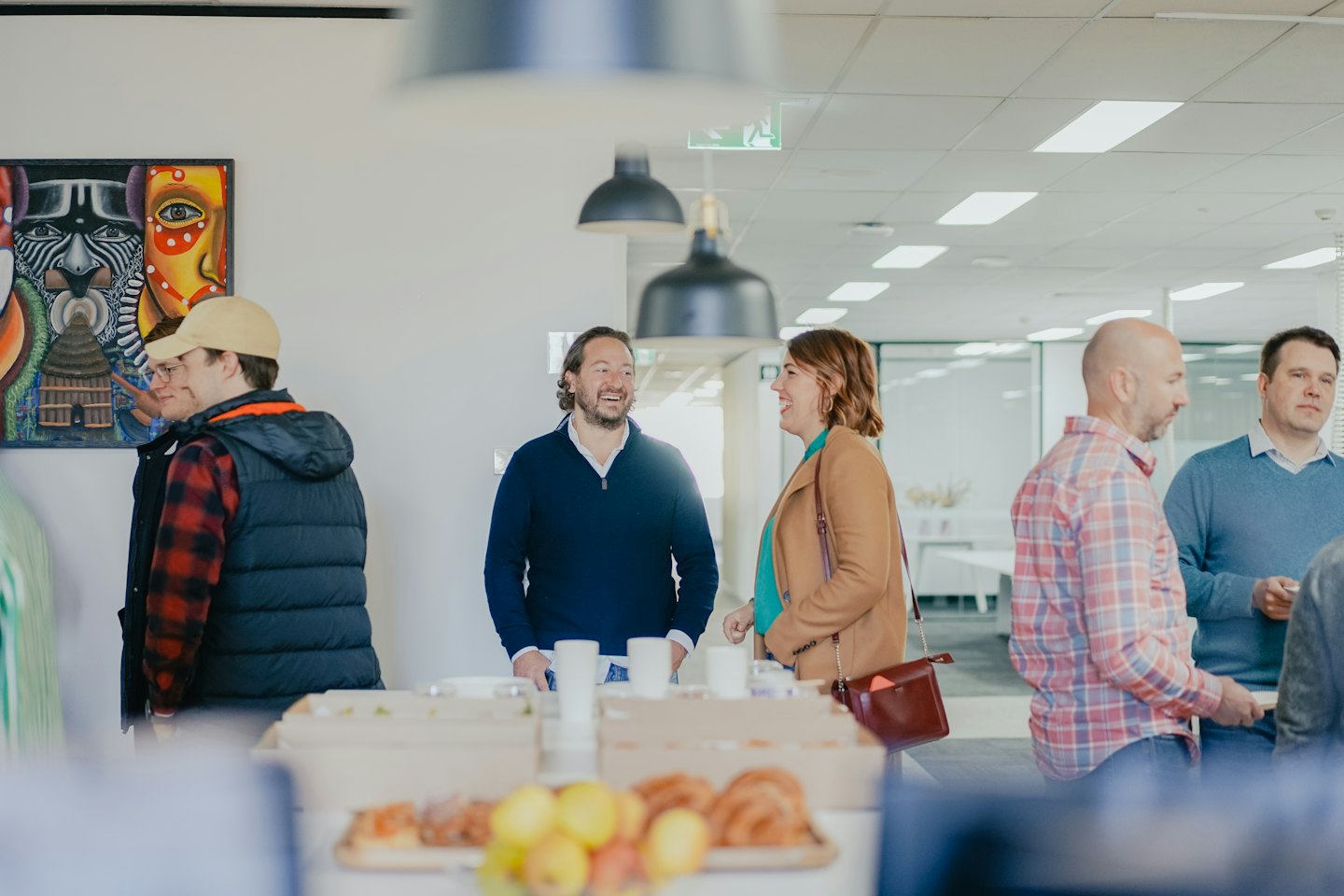 Un grupo de profesionales riendo y charlando en un evento corporativo.