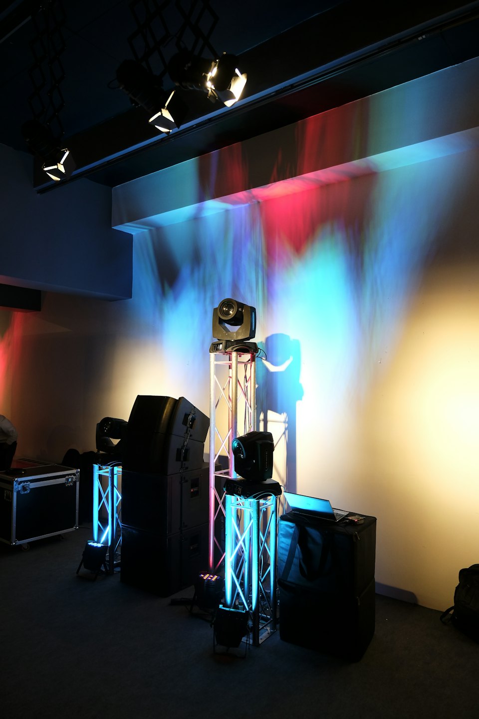 Equipo de iluminación y sonido en un local oscuro con luces de colores.
